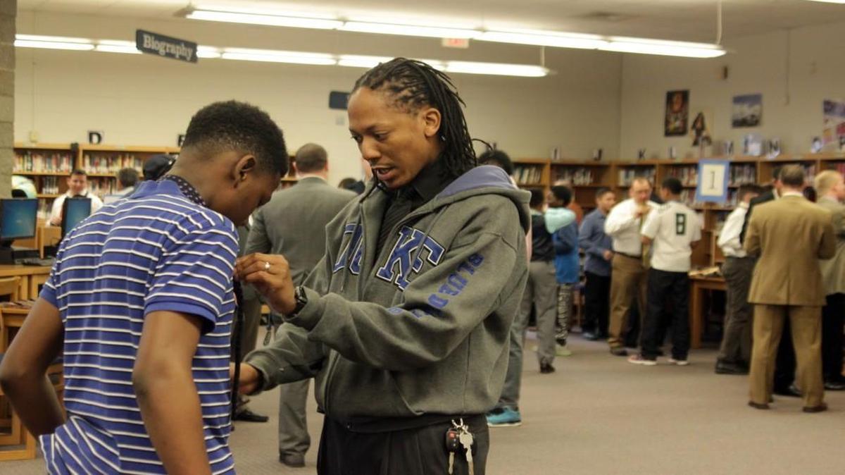 Clarence Morgan, right, a counselor at East Garner Middle School, teaches sixth-grader Trey Smith how to tie a tie. The Wake County school board wants a $45.2 million increase in local funding, with $10 million of it going toward hiring more guidance counselors and social workers.