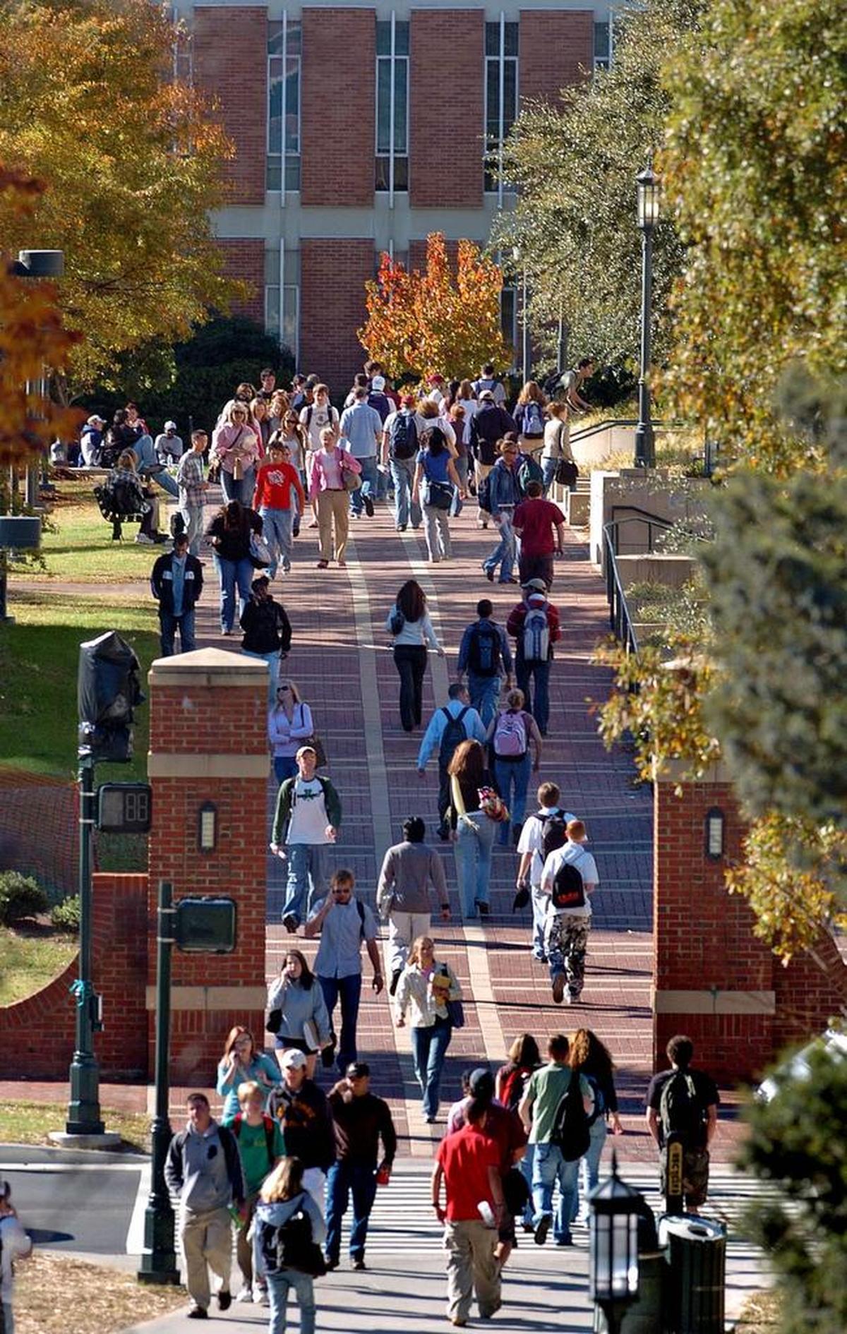 UNC Charlotte students crowd a campus walkway between classes.