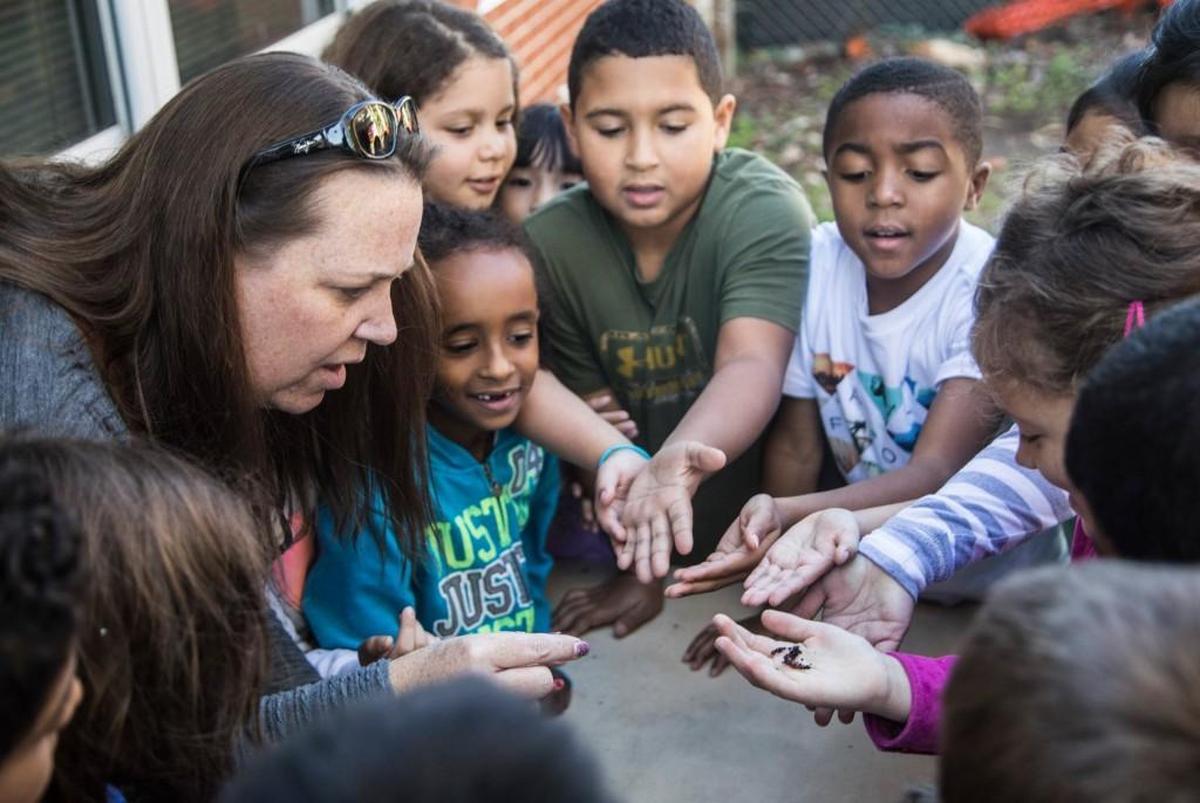 Megan Jackson, left, an environmental inquiry specialist, conducts a hands-on activity with second-graders and worms during an outdoor lesson at Lincoln Heights Elementary School in Fuquay-Varina on Oct. 26, 2017. State legislators are studying whether to overhaul the way North Carolina funds public schools.