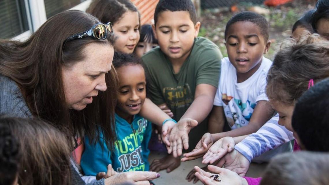 Megan Jackson, an environmental inquiry specialist specialist, left, conducts a hands-on activity with second-graders and worms during an outdoor lesson at Lincoln Heights Elementary School in Fuquay-Varina on Oct. 26, 2017. State legislators are studying whether to overhaul the way North Carolina funds public schools.