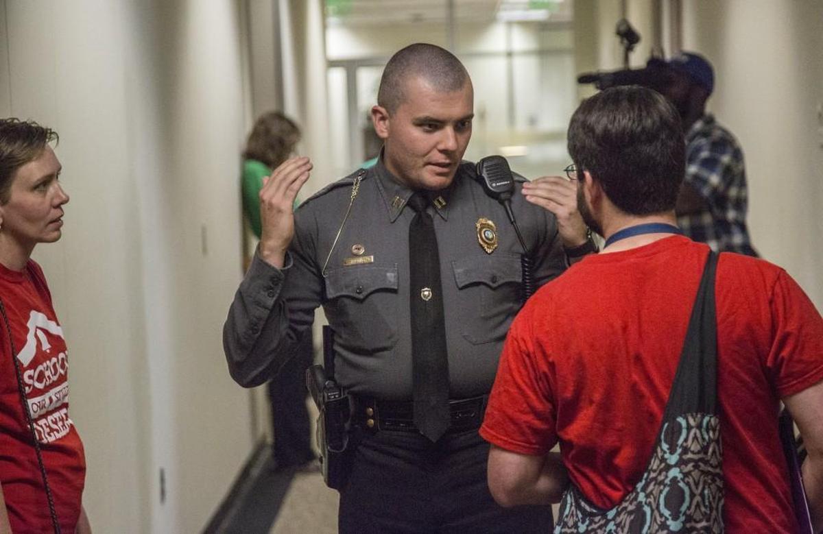 A Capitol police officer urges Nicholas Graber-Grace, a protest organizer, to leave the premises at 5 p.m. as Durham elementary school students, teachers and parents hold an art lesson and protest inside Sen. Chad Barefoot’s office in the Legislative Office Building in Raleigh Wednesday, Tuesday, May 3, 2017. The group urged state lawmakers to increase education funding.