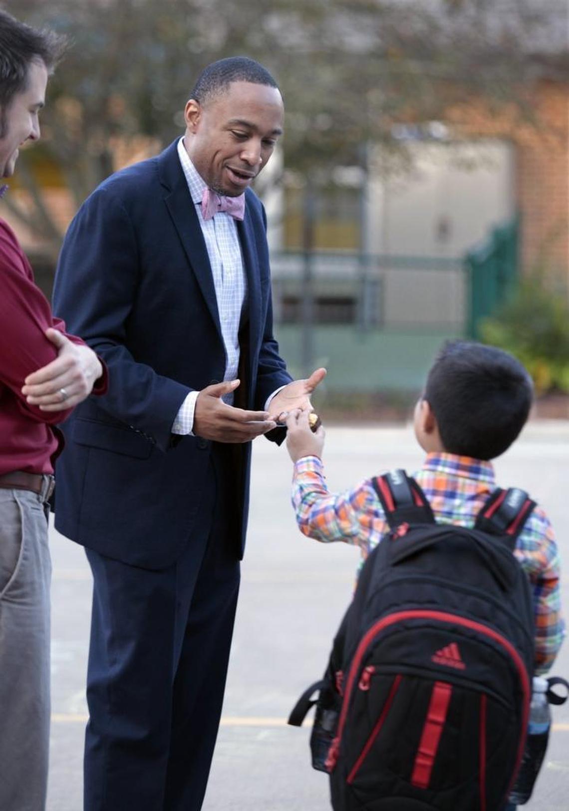 Brentwood Elementary principal Eric Fitts, 41, receives a small gift from one of his arriving students Thursday morning, October 8, 2015 just before school begins. Fitts was honored Wednesday night as the Wake County school system’s 2015 Principal of the Year. Fitts has been principal at Brentwood for two and a half years at the 385 student K-5 magnet engineering school.