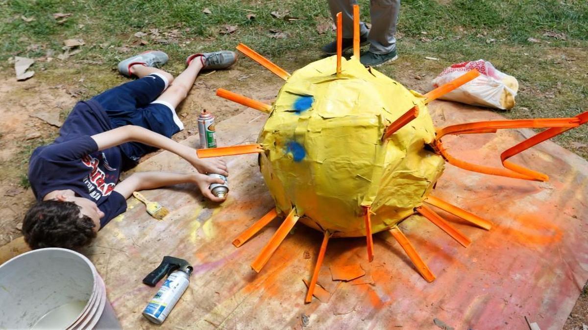 Raleigh’s Magellan Charter School 8th grader Ethan Celata got down and horizontal to spray paint his team's brightly colored blowfish on April 29, 2016. The State Board of Education voted Thursday, Feb. 2, 2017, to renew 29 North Carolina charter schools, including giving a 10-year extension to Magellan.