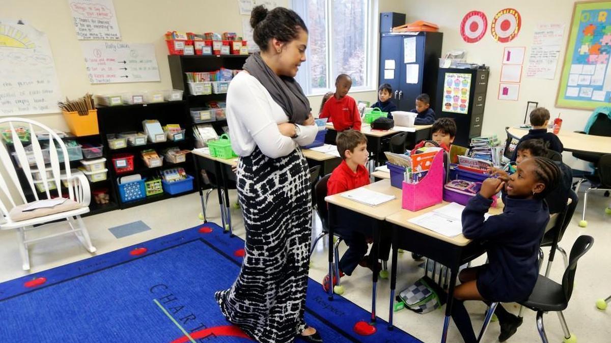 Second grade teacher Sarah Santiago talks with Prisca Viho during class at Cardinal Charter Academy in Cary, N.C., on Dec. 2, 2015. School leaders want to open a K-12 charter school modeled after Cardinal Charter on the border between Cary and Chatham County.