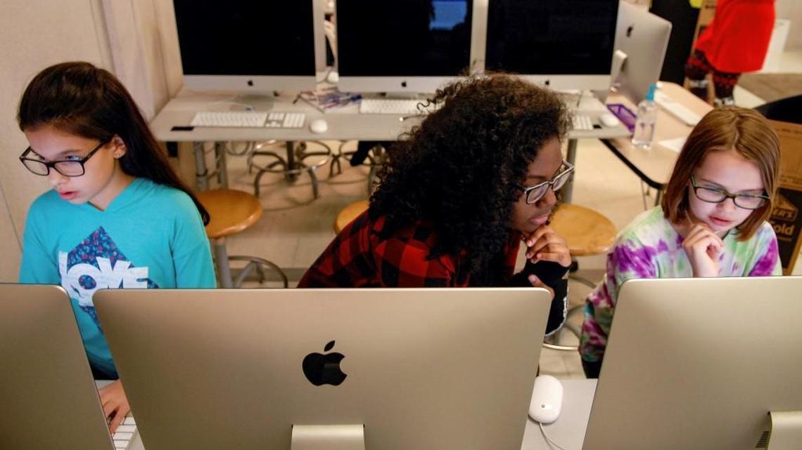 Olivia Mir, far left, and Jilly Casey, far right, design the gear their team will need to compete in a Lego League Robotics competition as part of a club sponsored by their school, Neuse Charter in Johnston County. De’ovyun LeRouge, center, a high school senior who wants to pursue a career in computer programming, helps the girls as part of a volunteering program at the school.