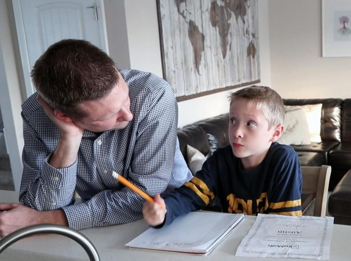 Brannon Balsley, left, helps his son Austin Balsley, 7, with his homework after school at their home in Holly Springs on Nov. 15, 2017. The kids attend Holly Grove Elementary, a year-round school but they're slated to go to Buckhorn Creek Elementary, a new traditional-calendar school opening in 2018. He and other Holly Grove parents are lobbying Wake to open Buckhorn Creek as a year-round school.
