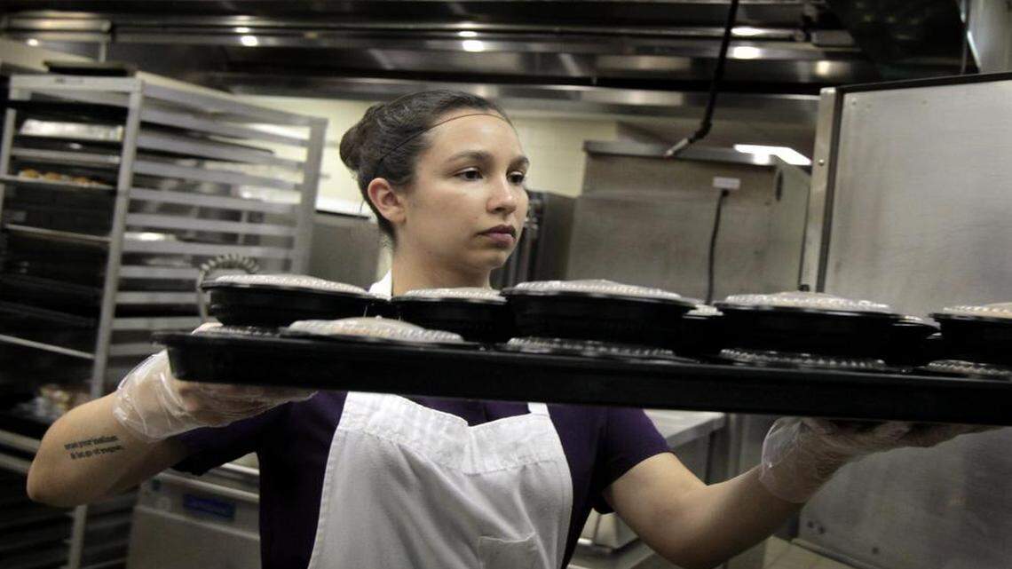 
Miranda Yerrick, a cashier/assistant, keeps food warm in ovens at Davis Drive Elementary School in Cary on Tuesday. 

