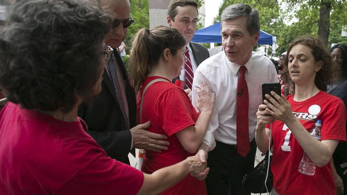 North Carolina Gov. Roy Cooper shakes hands with teachers after addressing their rally on the Bicentennial Mall on May 16, 2018, in Raleigh, N.C.