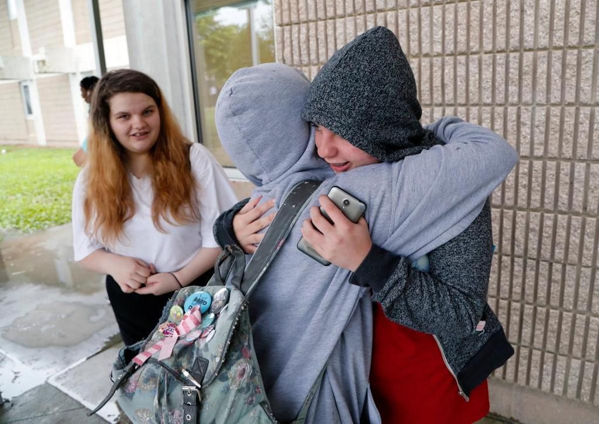 East Wake High School senior Megan Faircloth, right, gets a congratulatory hug from a classmate at the end of the school day on June 5, 2017. Megan's sister Jacey Faircloth looks on at left. Megan spoke at a recent awards ceremony about being homeless during her junior year. She persevered through the adversity to achieve the highest class rank and received a near- full scholarship to Stanford Univ.