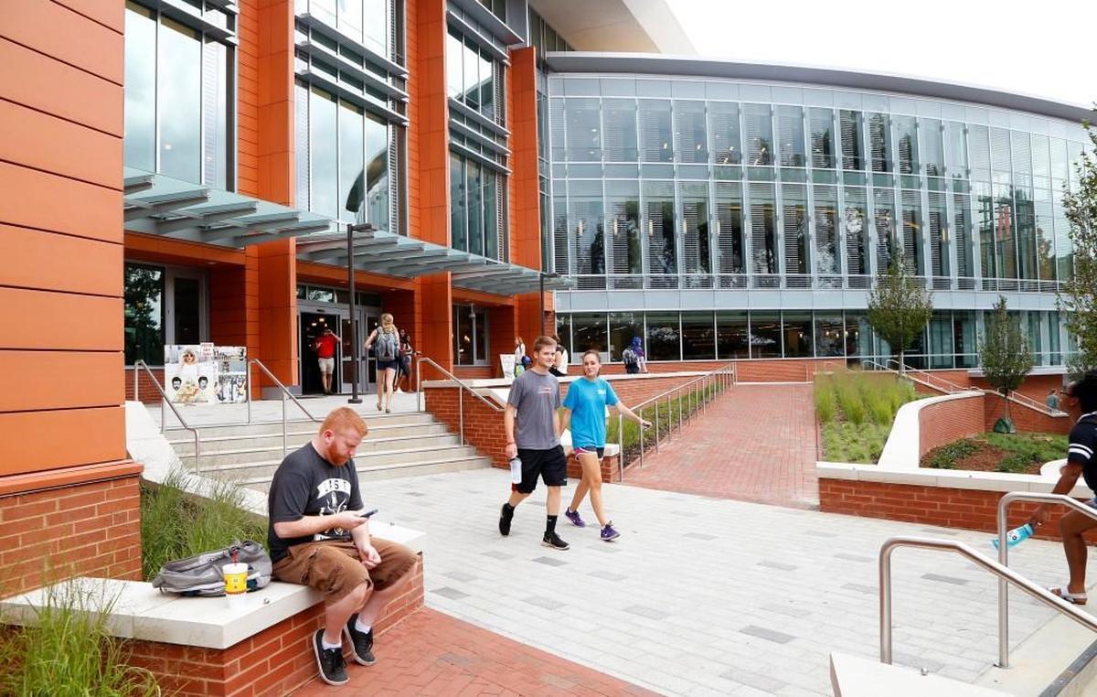 Quinton Buesching, left, checks his smartphone as he sits outside the Talley Student Union by Cates Ave. on the N.C. State campus on August 19, 2015. The building was renovated in two separate operations; it is now finished and open. 
