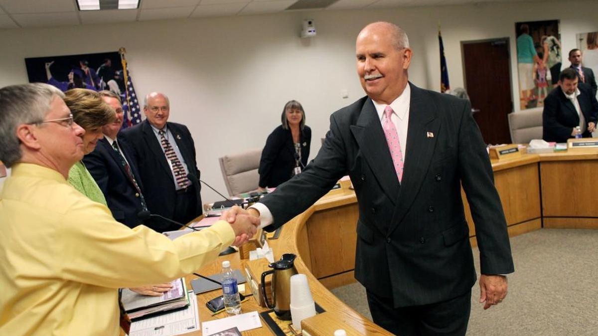 Jim Merrill, center, shakes hands with Wake County school board members after he was named superintendent in 2013. The school board is now looking for a replacement for Merrill, who will retire Feb. 1.