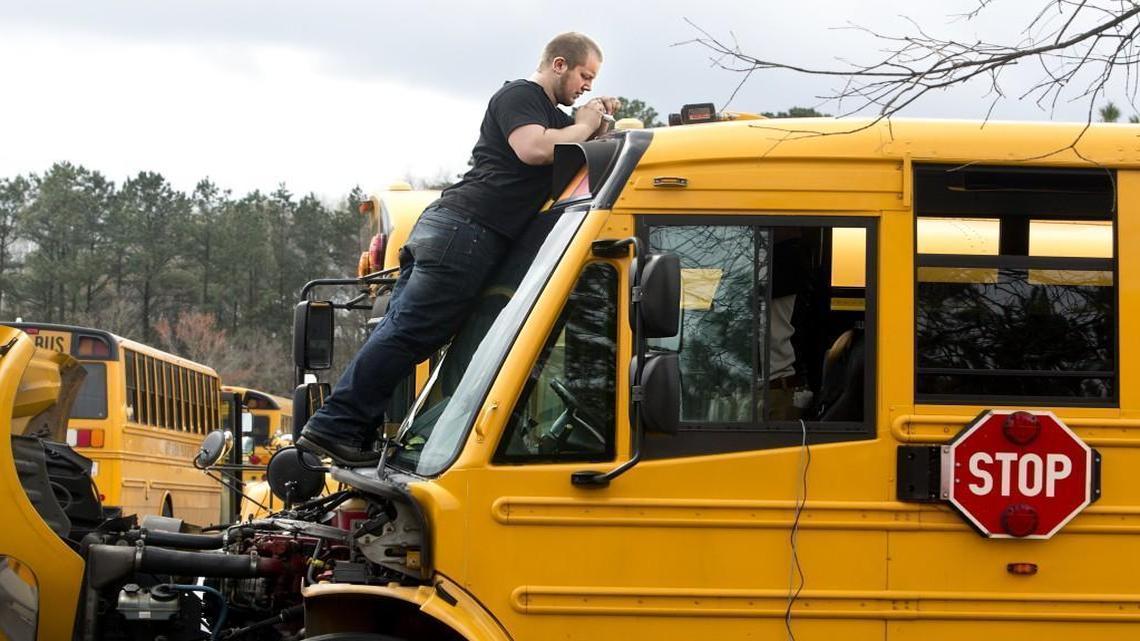 Robert Carver, with Fortress Mobile, installs a wifi/GPS antenna on a Wake County school bus in Raleigh on March 26, 2015. Four cameras were mounted inside the bus for monitoring everything from the riders to the speed of the bus to the braking.