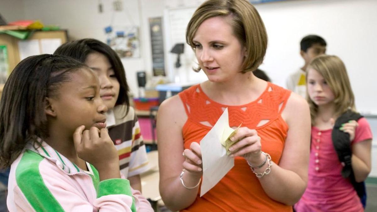 Jenny Bajorek, a 5th grade teacher at Northwoods Elementary, talks to one of her students Sumera Ingram, left. Bajorek became a teacher through N.C. Teaching Fellows Program.