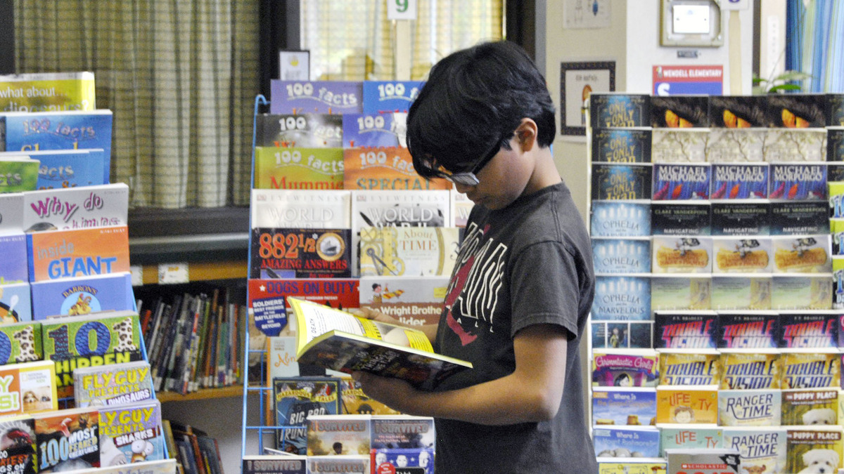 Ramses Calderon, a 5th-grader at Wendell Elementary, chooses a book at the school’s book fair in this 2015 file photo.