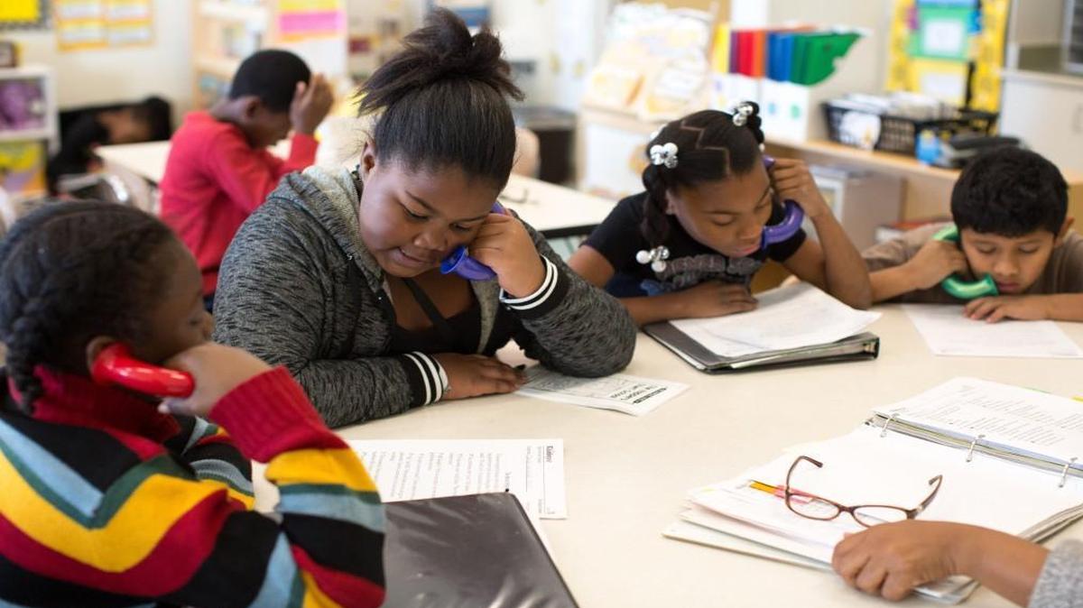 From left, Jerry Crisler, 9, Aniya Pettiford, 10, Aniyah Alford, 10, and Miguel Candela, 10, use 'whisper phones' to listen themselves read out loud during writing and reading in their fourth-grade class at Walnut Creek Elementary School on Jan. 11, 2016 in Raleigh, N.C. Wake County school leaders want the public’s help in picking new materials that will be used in language arts classes in elementary and middle schools and math classes in high school.