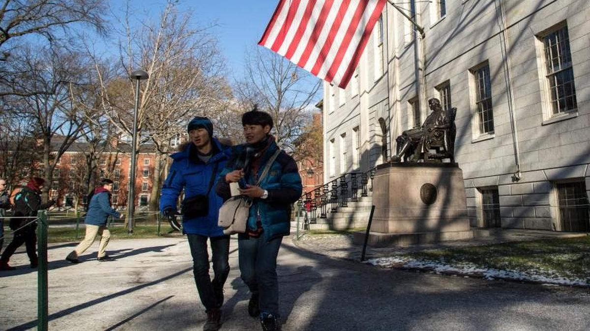 Tourists and prospective students visit the Harvard University Campus in Cambridge, Mass., Thursday. An outsider slate of candidates running for the Board of Overseers at Harvard, which helps set strategy for the university, is posing the provocative question of free tuition.