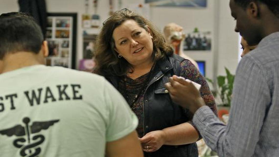 
East Wake School of Health Science teacher Sandy Tyndall, center, quizzes pharmacy tech senior Dennis Mongare, right, in a prescription drug recognition exercise on March 4. 
