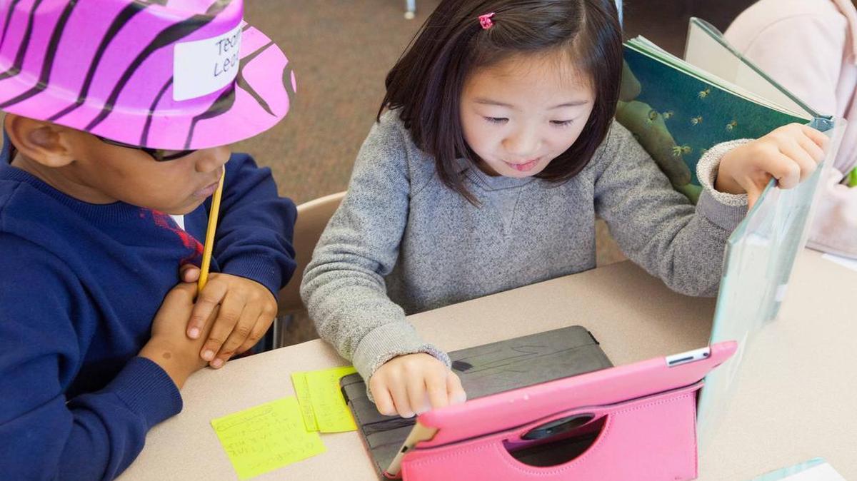 
Christian Washington, left, and Hanna Walker work together using an iPad to learn facts about octopi in Caroline Page's first-grade class at Brier Creek Elementary in December 2014 in. Brier Creek was one of the 13 pilot schools for Wake County's Bring Your Own Device program, which is now being expanded to more than 40 additional schools.
