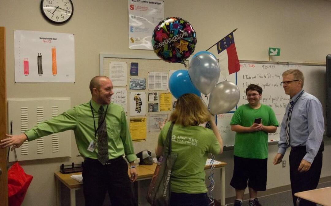 Heritage High School teacher Miles Macleod, left, was surprised Thursday, May 12, 2016, by teachers and faculty, including principal Mark Savage, far right. On Wednesday, Macleod was named the Wake County school system’s 2016 Teacher of the Year.