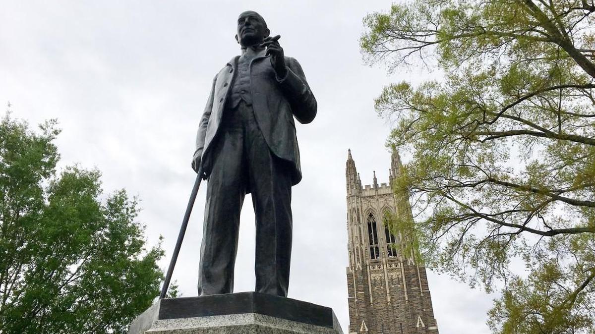 A statue of James Buchanan (Buck) Duke greets visitors to West Campus at Duke University. Duke Chapel is pictured at rear.