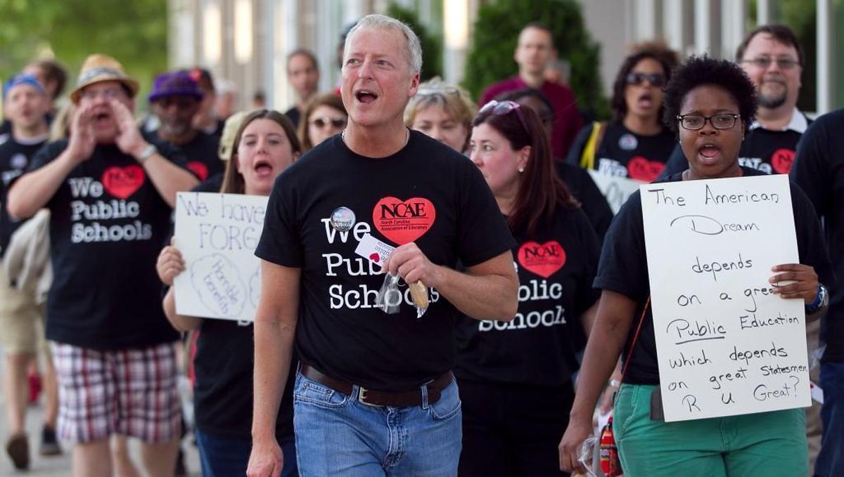 Mark Jewell, then the vice president of the N.C. Association of Educators, marches with other educators in Raleigh in 2014 to call on state legislators to raise teacher pay.