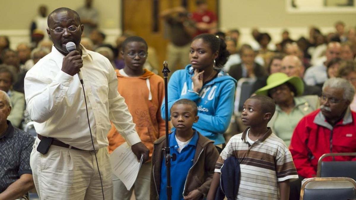 Darryl Fulton of Raleigh, N.C. speaks out against discrimination as he stands with his four children during a public hearing before a panel from the Office of Civil Rights from the Department of Education on Wednesday May 4, 2011 at Martin Street Baptist Church in Raleigh, N.C. Jacob Fulton (age 8) Isaac Fulton (center) (age 7) (right), Bre Anna Fulton (age 14), and Zachary Fulton (age 12).