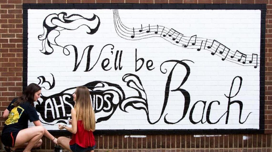 Students, alumni paint parting messages in the halls of Apex High