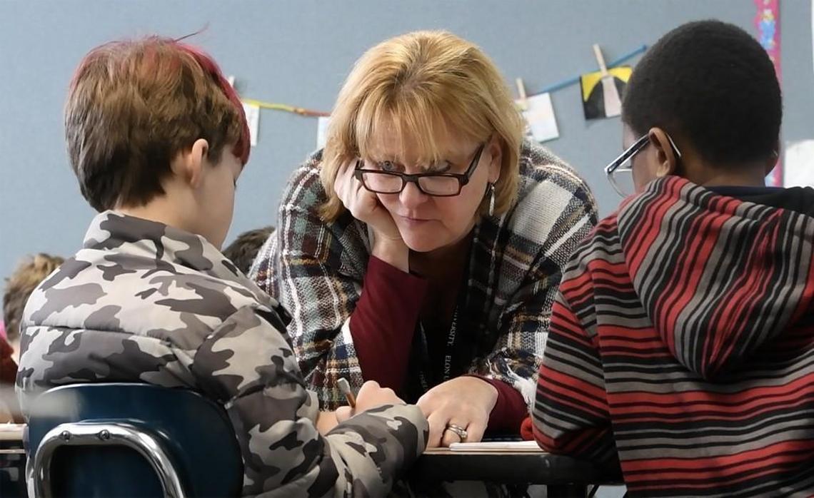 Nancy Bergquist works a math problem with two of her fourth-grade students at Washington Elementary School on Thursday, Dec. 14, 2017. She’s one of the many teachers who lost the chance to get tenure when the General Assembly took the option away.