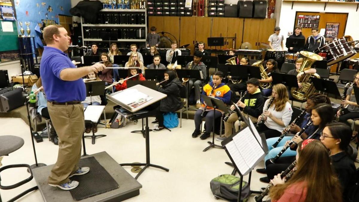 Instructor Daniel Jarvis at left leads his concert band II class of Apex High School students through their music on Jan. 28, 2016. Apex High could start 15 minutes earlier in fall 2017 at 7:10 a.m. at a time when some other school districts are moving high schools to a later start time.