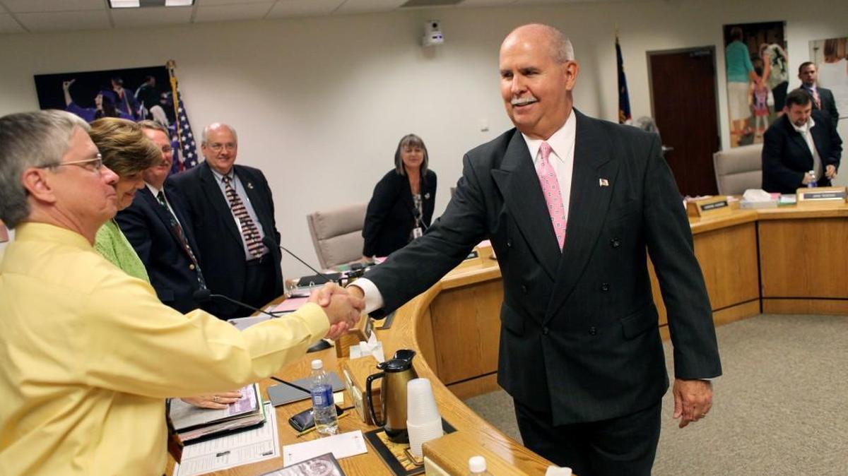 Jim Merrill, center, shakes hands with Wake County school board members including Kevin Hill, left, after Merrill was named the new Wake County Schools superintendent during a board meeting on June, 18, 2013. Merrill announced Tuesday that he’ll be retiring as Wake superintendent on Feb. 1, 2018.