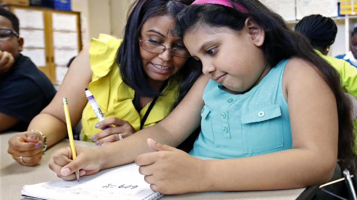 From left, Barwell Road Elementary school teacher Yolanda Roman helps 2nd grader Eneida Guillen-Oregon learn subtraction with 10s and 100s during math period in Roman's homeroom. Barwell Elementary is one of two Wake County schools the Wake School system that wants state permission to operate more flexibly like charter schools to help improve student performance.
