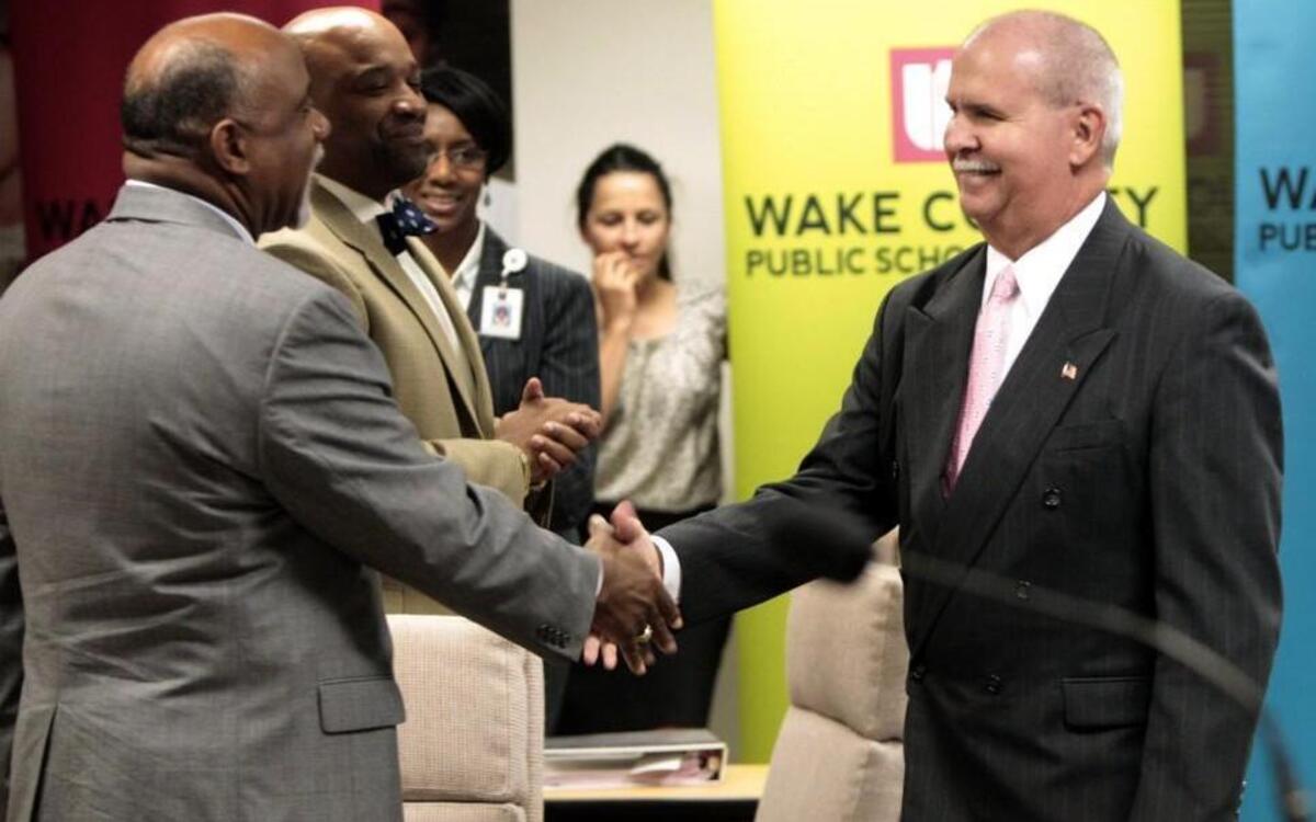 Jim Merrill, center, shakes hands with Marvin Connelly, assistant superintendent for student support services, after Merrill was announced as the new Wake County Schools superintendent during a school board meeting on June, 18, 2013. On April 11, 2018, Connelly was announced as the new superintendent of Cumberland County schools.