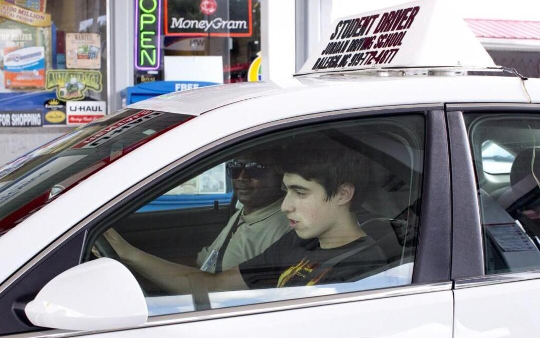 Asher Philips, 15, runs through a driving checklist alongside instructor Curtis Wilson during the behind-the-wheel portion of the driver’s education program run by Jordan Driving School on Aug. 19, 2015.