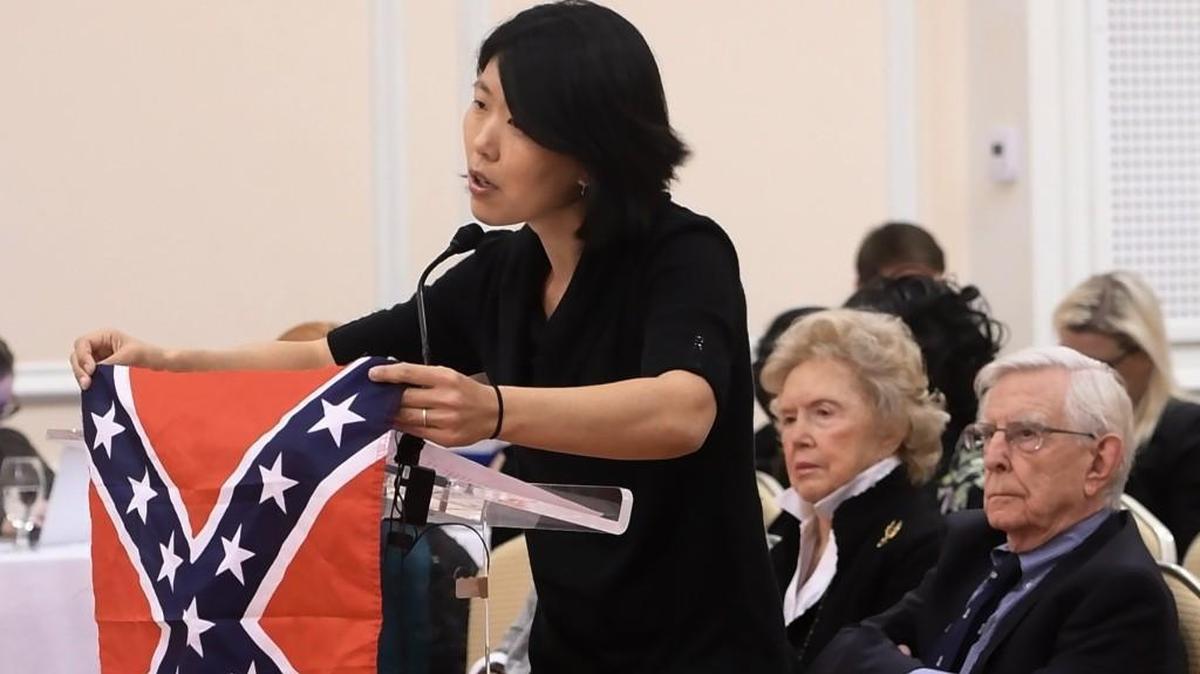 Heather Redding, 39, an Orange County resident married to a UNC alumnus, holds up a Confederate Battle flag as she urges the UNC-Chapel Hill Board of Trustees to remove the controversial Silent Sam statue. She spoke at a public hearing in November.