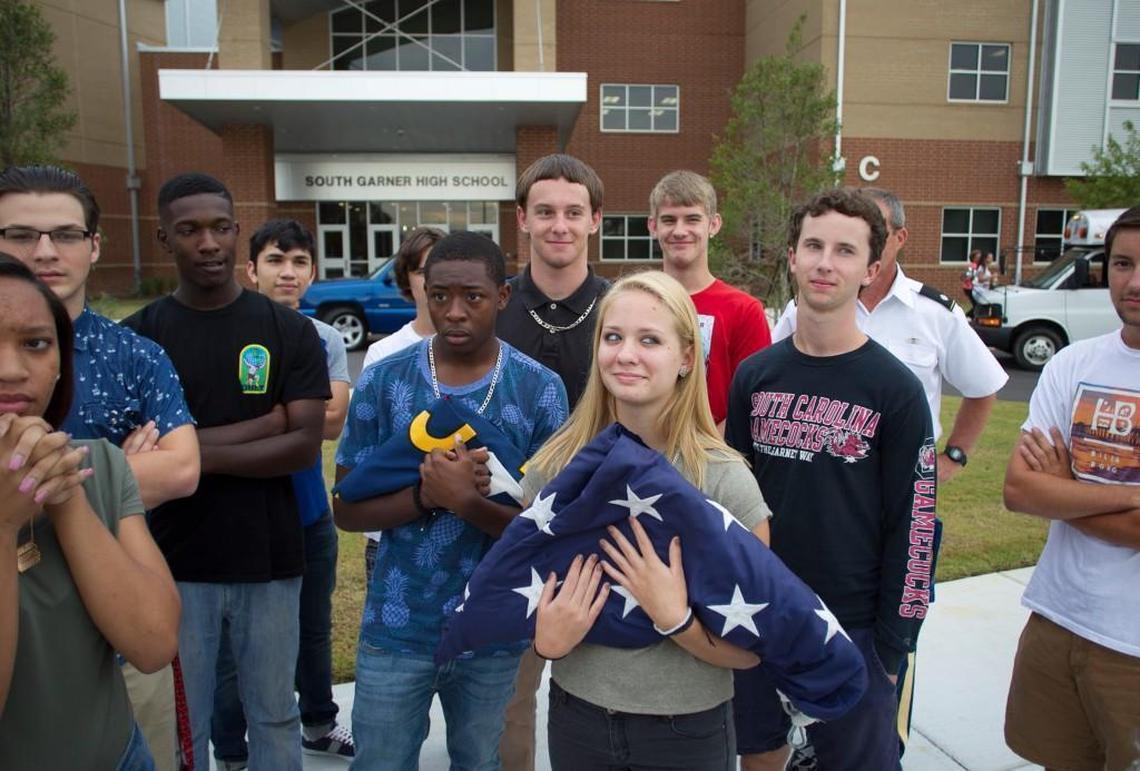 Garner High School student Ashley Zimmerman, a senior member of the Army Junior ROTC, holds the American Flag as she and fellow JROTC members learn how to use the new flag poles at South Garner High School on the first day of school for traditional calendar students Monday, August 29, 2016 in Garner, N.C.