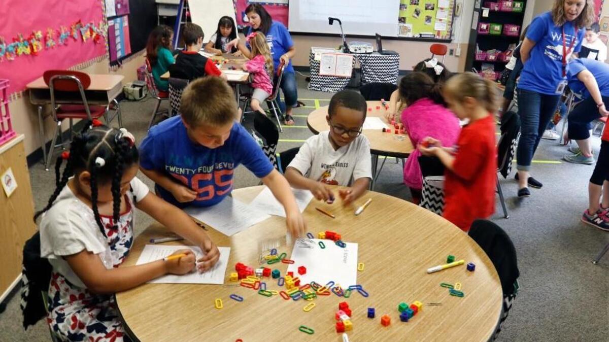 From left at foreground table, Wendell Elementary School first graders Tierra Thompson, Cameron Pounds and Silas Lucas measure paper with paper clips in homeroom teacher Jenny Richards' class on May 15, 2015. Wake County school administrators are recommending placing enrollment caps on 21 schools for the 2018-19 school year, including Wendell Elementary.