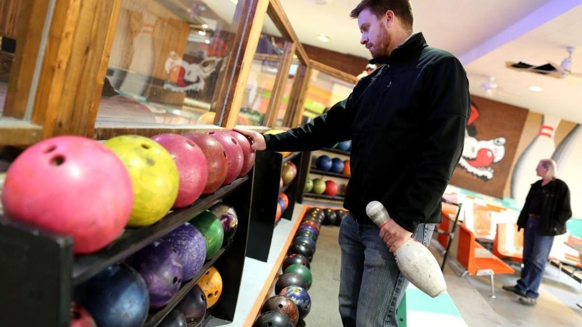 Dan Barnes inspects bowling balls during a silent auction at The Alley on Sunday, Nov. 27, 2016. With The Alley closing, items were being auctioned, with money raised benefiting former N.C. State baseball standout Chris Combs, who was diagnosed with ALS in May.