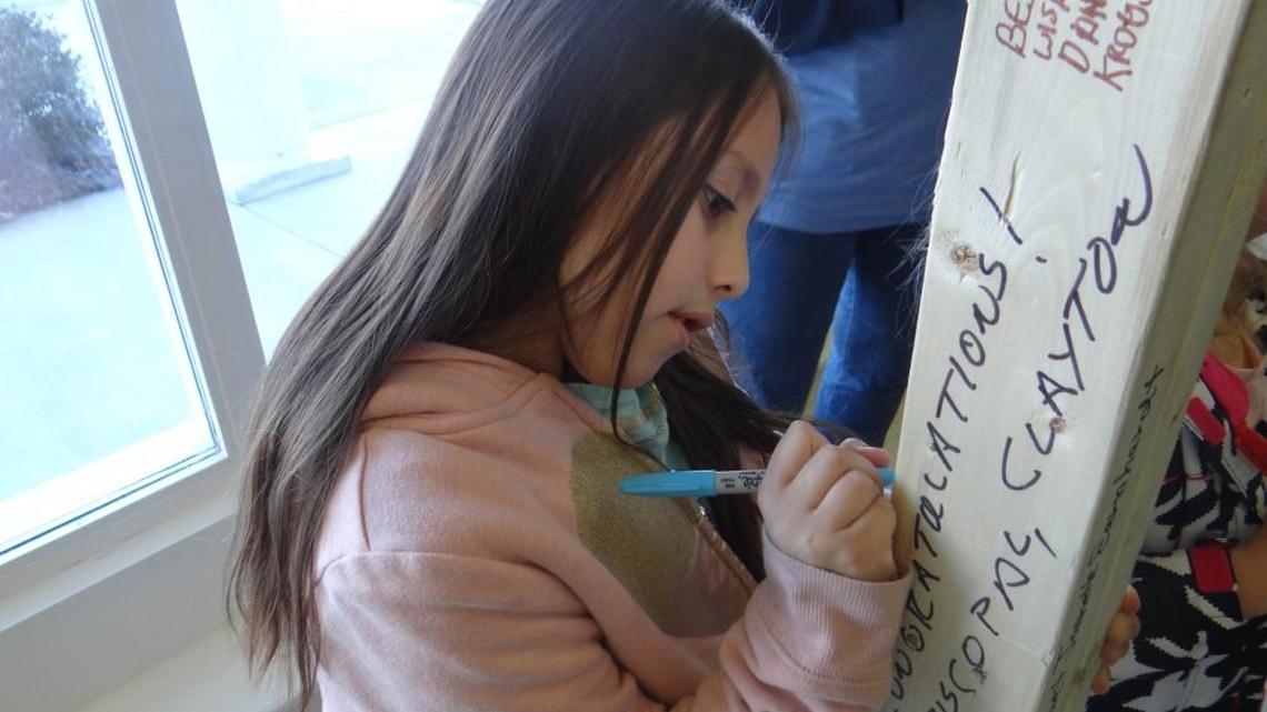 Evelyn Morgan signs the frame of the door of her future home.