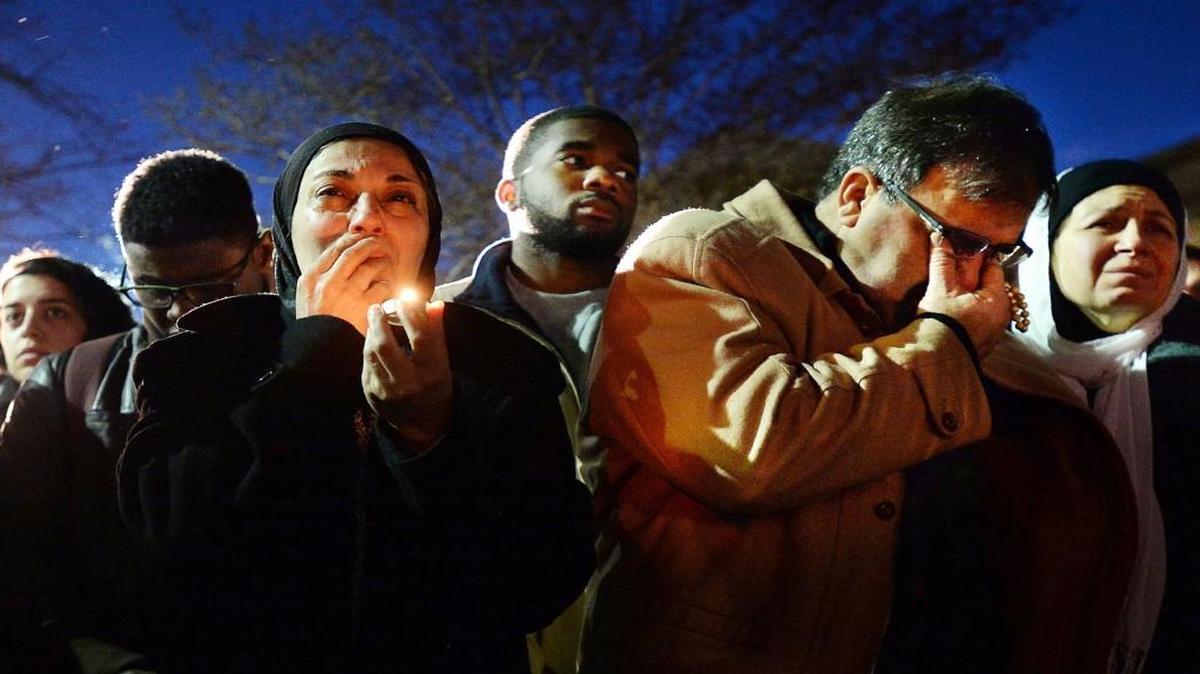 Namee Barakat (center) wipes away tears as he and his Layla (right cq) break into tears while watching a photo presentation during a vigil for his daughters who were shot to death Tuesday, Feb. 10, 2015 in Chapel Hill, NC . Craig Stephen Hicks, 46, of Chapel Hill is accused of shooting Deah Barakat, 23, his wife Yusor Abu-Salha, 21, and Abu-Salha's sister, Razan Abu-Salha, 19, of Raleigh. NOTE: WOMAN AT LEFT IS UNIDENTIFIED