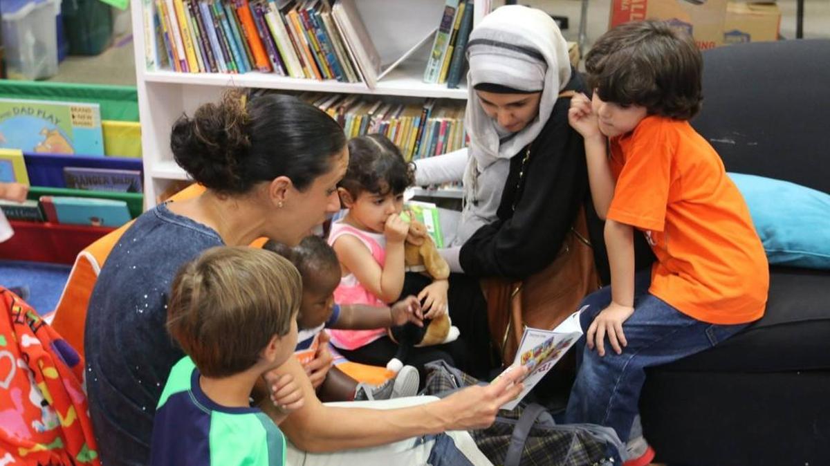 Book Babies Team Leader Meytal Barak reads with Book Babies families who come to the Book Harvest office to choose more books to take home to build their home libraries.
