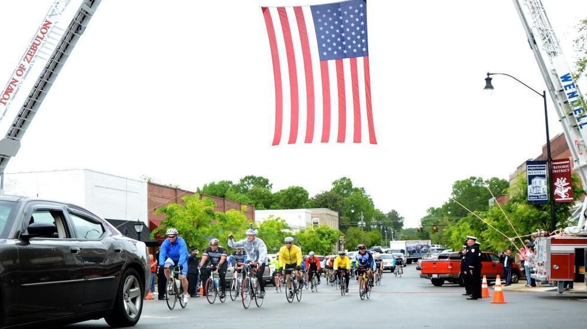 Bikers are saluted by members of the Wendell and Zebulon fire departments as they ride under an American flag suspended by ladder trucks of the two departments before crossing the railroad tracks in downtown Wendell in 2013.