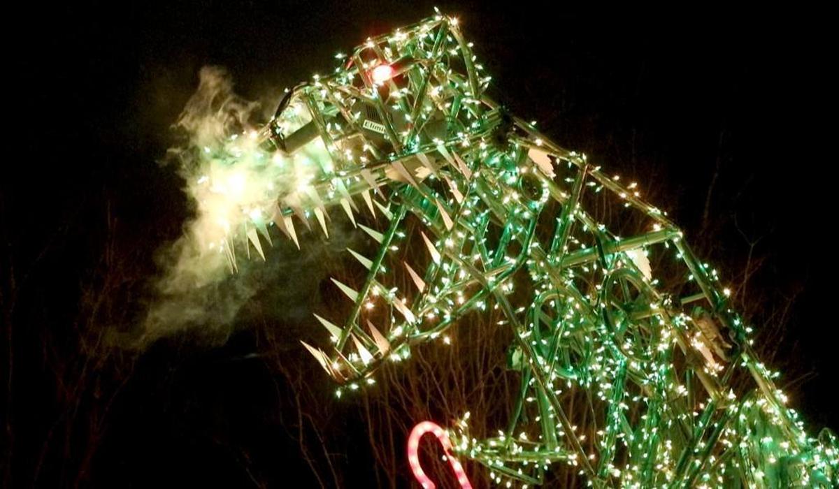 A big dinosaur covered in lights moves, snorts smoke and holds a candy cane as part of a display at a home at 6001 Countryview Lane in Raleigh.