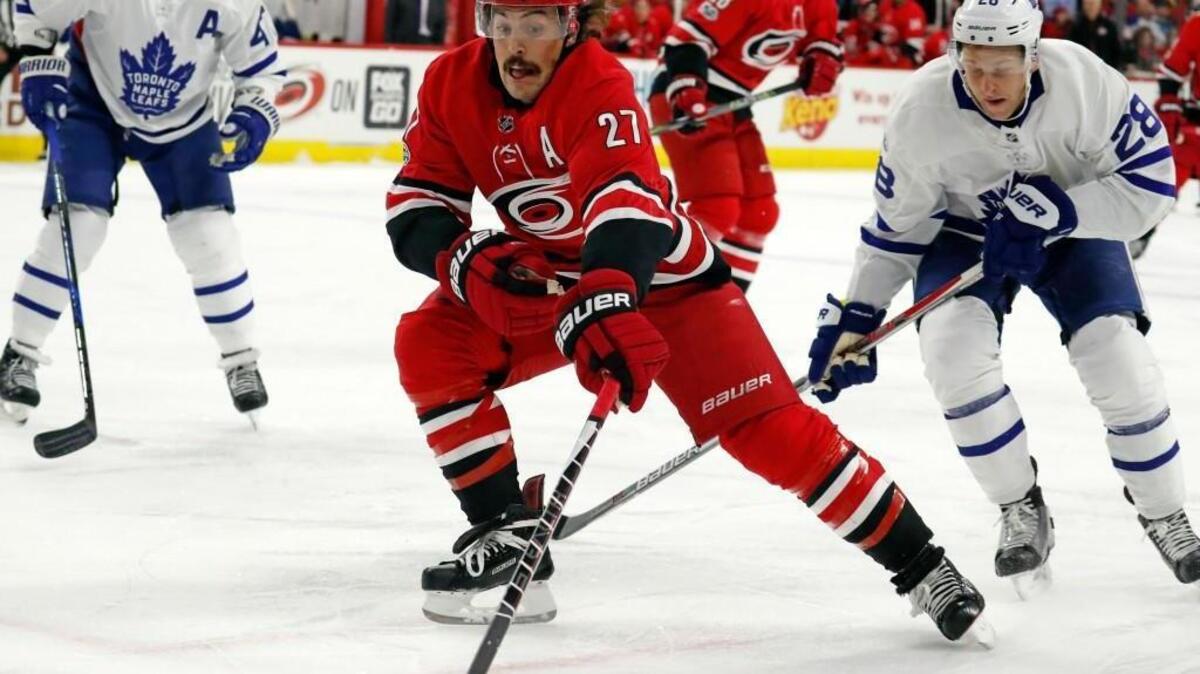 The Canes’ Justin Faulk (27) and the Leafs’ Connor Brown (28) go for the puck during the first period of an NHL game played between the Carolina Hurricanes and the Toronto Maple Leafs at PNC Arena in Raleigh, N.C. on Nov. 24, 2017.