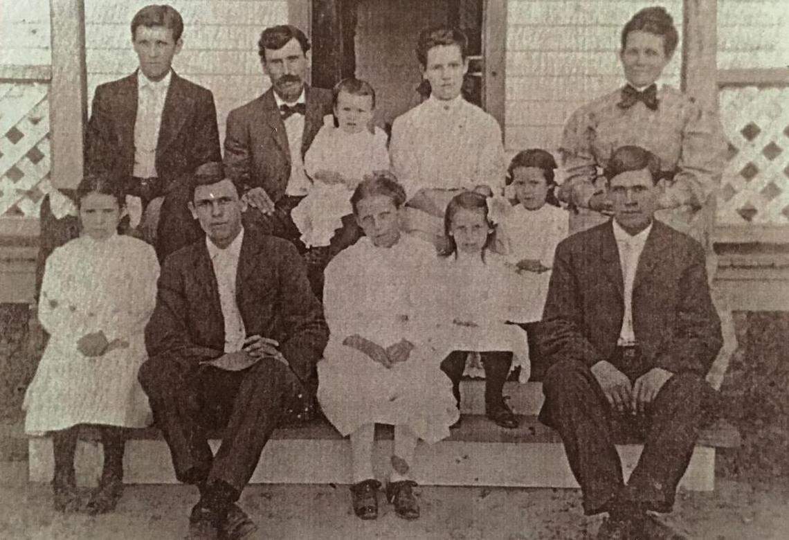 A young Foster Stevens (top row, far left), and his sister Ina (front row, far left) pose with their parents and seven other siblings on the front porch of their North Carolina home in 1908.