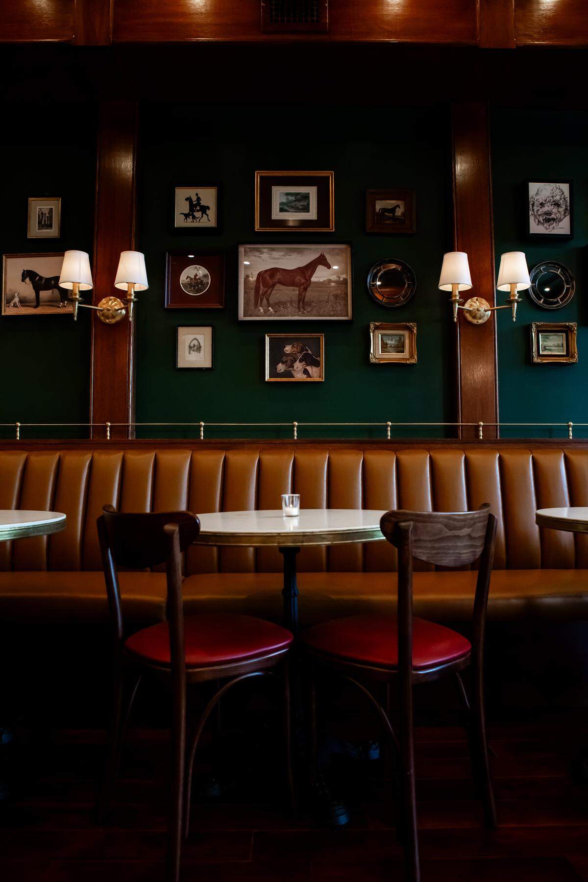 Photos depicting horses line the wall of Mr. Henry, the new cocktail bar at Village District.