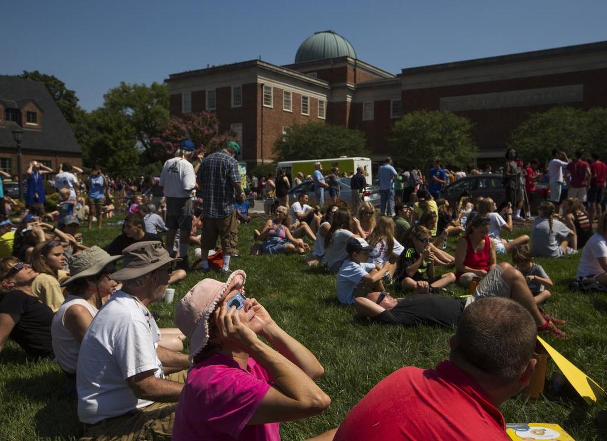 Kathy Newell views the solar eclipse with glasses during a solar eclipse celebration at the Morehead Planetarium on Monday, Aug. 21, 2017, in Chapel Hill, NC.