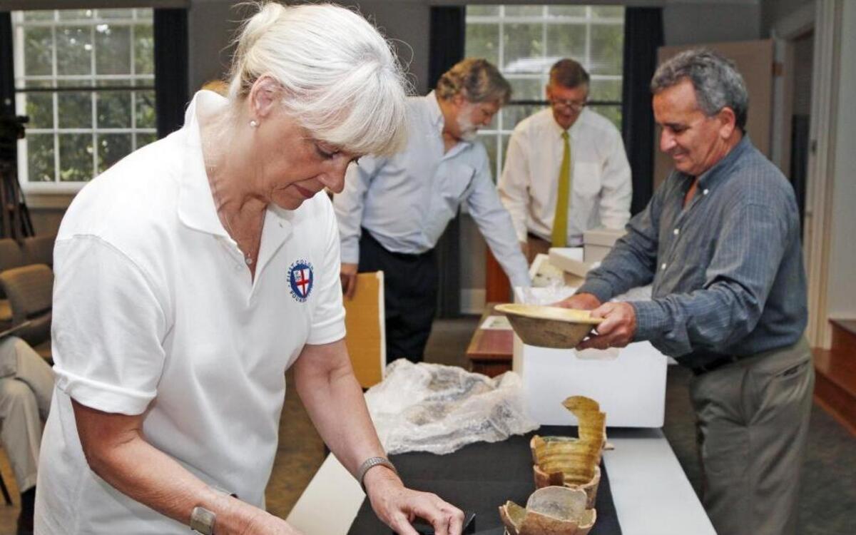 First Colony Foundation curator Bly Straube compares pottery shards found at Site X to other 16th-century pottery in this 2015 photo. The Coastal Land Trust said Wednesday it has acquired the 1,000-acre site in Bertie County and plans to transfer it to state ownership.