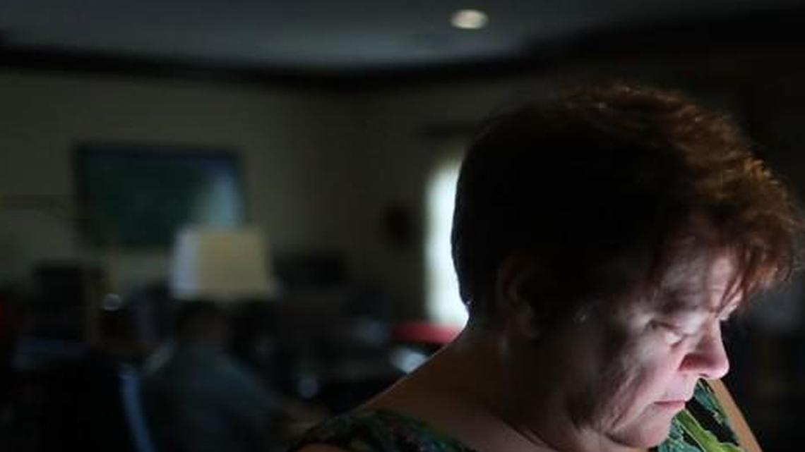 Amy Currin watches the weather news on her cell phone in Texas. Some apps can be particularly useful if your home electricity is out.