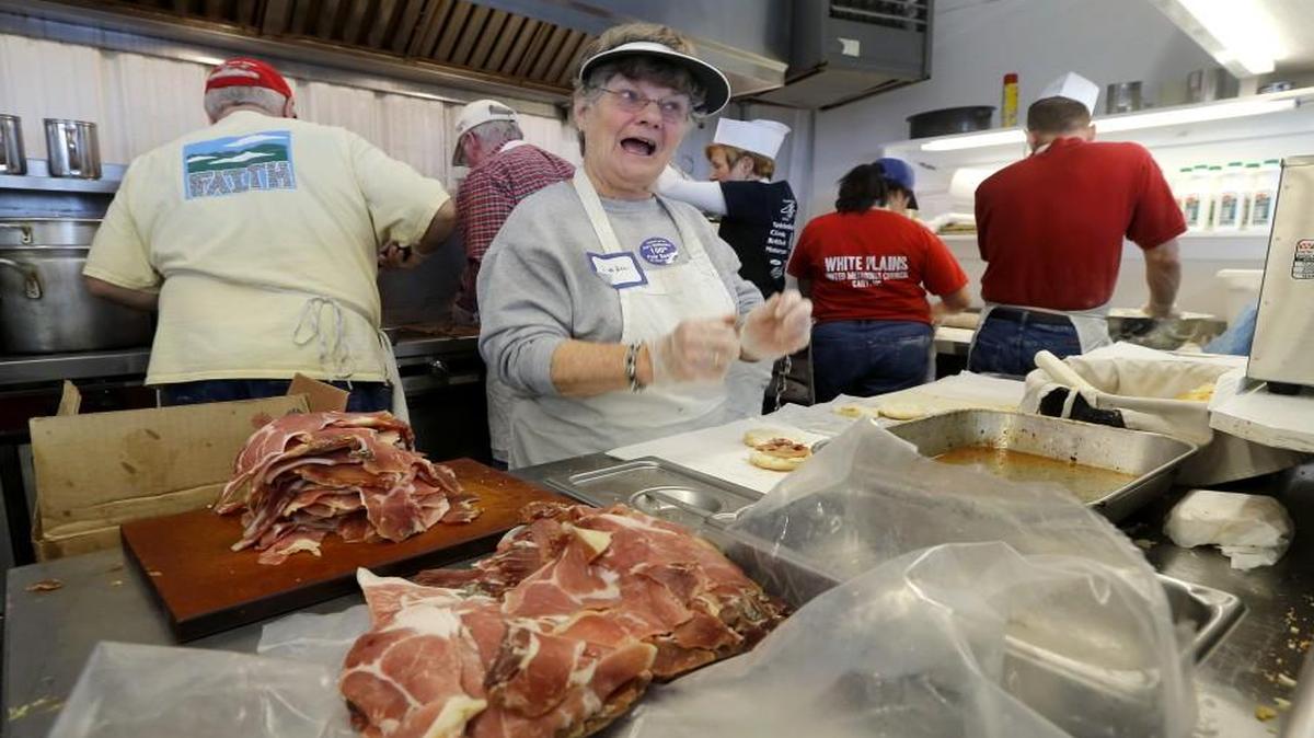 
Of all the traditions at the N.C. State Fair, few are as enduring as the ham biscuits made and sold by Cary First United Methodist Church. The church has been selling them at the fair since 1916, when the $13 and change in profits that year went to buy carpet for a room in the church. Here Linda Huffman, who puts the ham on the biscuits, flashes a smile at a customer while she works at their location at the State Fair in Raleigh on Monday, Oct. 19, 2015.
