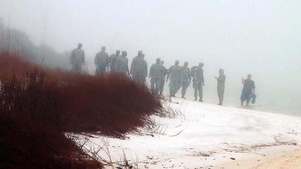 
Military personnel wade in the water and search on the beach under heavy fog at Eglin Air Force Base, Fla., on Wednesday for the wreckage of a military helicopter that crashed with 11 Marines and soldiers aboard. The helicopter went down late Tuesday evening. A Pentagon official says the 11 servicemen are presumed dead.

